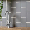 A sleek brushed silver kitchen faucet with curved spout and rounded handle in liso plata brillo 100x200 design