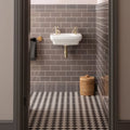 White ceramic wall-mounted sink with gold-toned faucets and plumbing featuring london stone egg and dart moulding