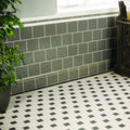 Gray rectangular london stone skirting wall tiles with white grout and decorative border above for interior use