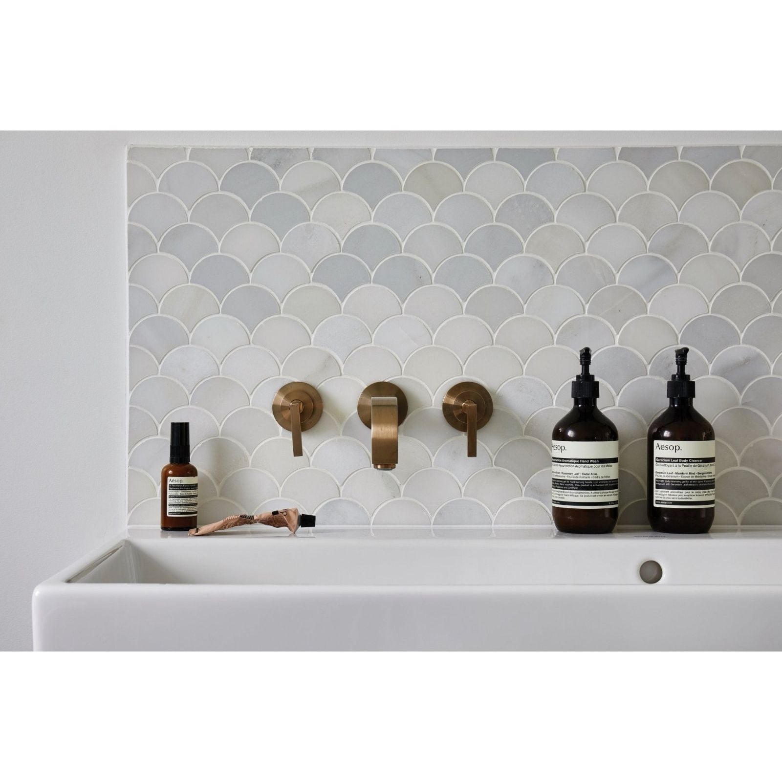 Long Island Marble Scallop Mosaic grey marble scallop mosaic with a white sink and brass taps
