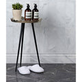Long Island Marble Skirting Honed Finish white marble skirting with a tripod plant stand and bottles