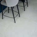 Modern gray upholstered bar stool with sleek black metal legs and circular footrest for Louvre Porcelain Blanc 80 x 80cm