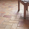 Lubelska brick terracotta rustic terracotta-colored rectangular floor tiles arranged in a herringbone pattern
