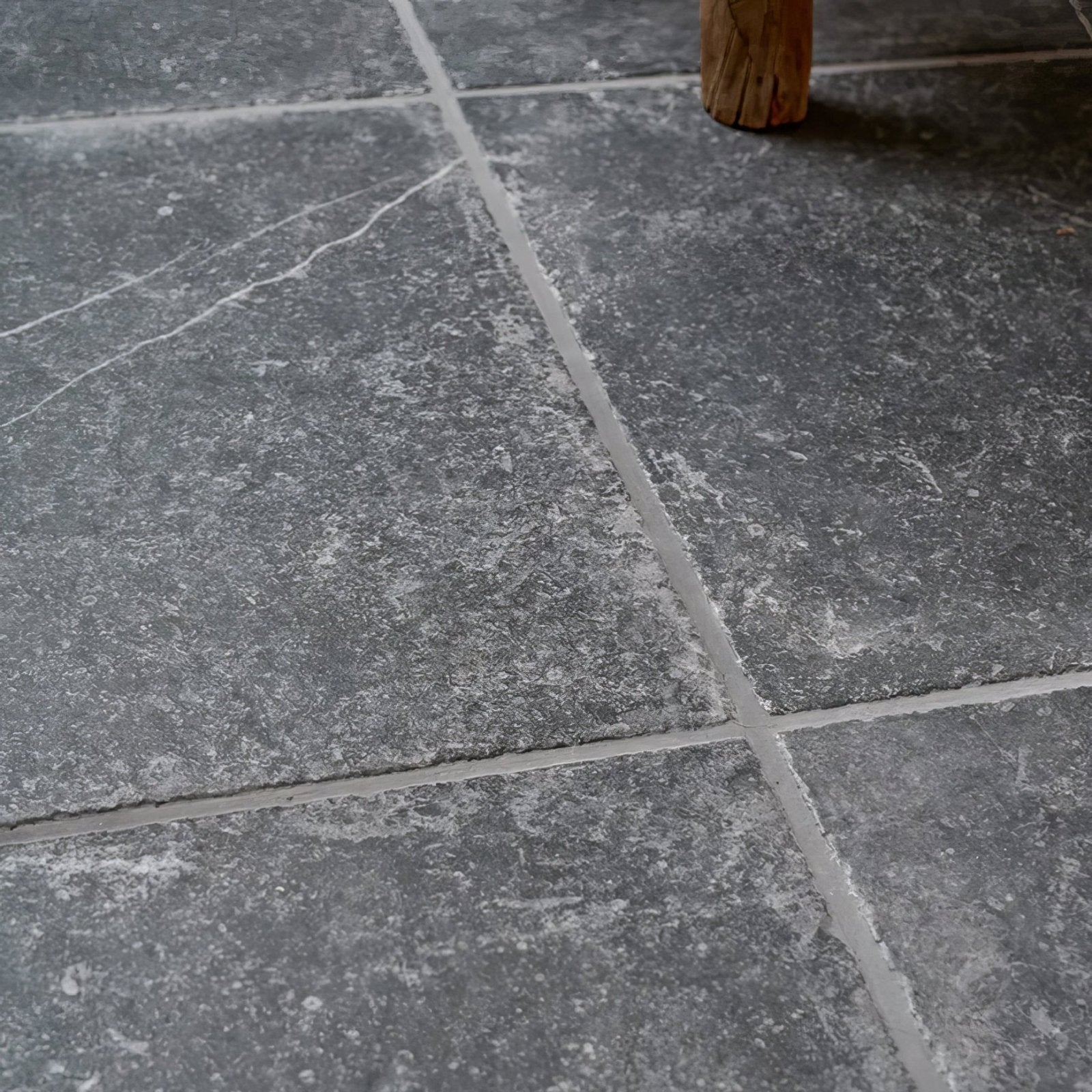 Ludlow porcelain charcoal dark gray stone tiles with subtle white veining and textured surfaces separated by thin grout lines