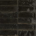 Dark gray rectangular luminous lume black tiles with distressed mottled finish arranged in a grid pattern