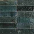 Dark teal rectangular ceramic tiles with a distressed weathered finish from the luminous lume blue collection