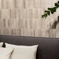 Gray textured rectangular wall tiles arranged in vertical rows from luminous lume greige collection