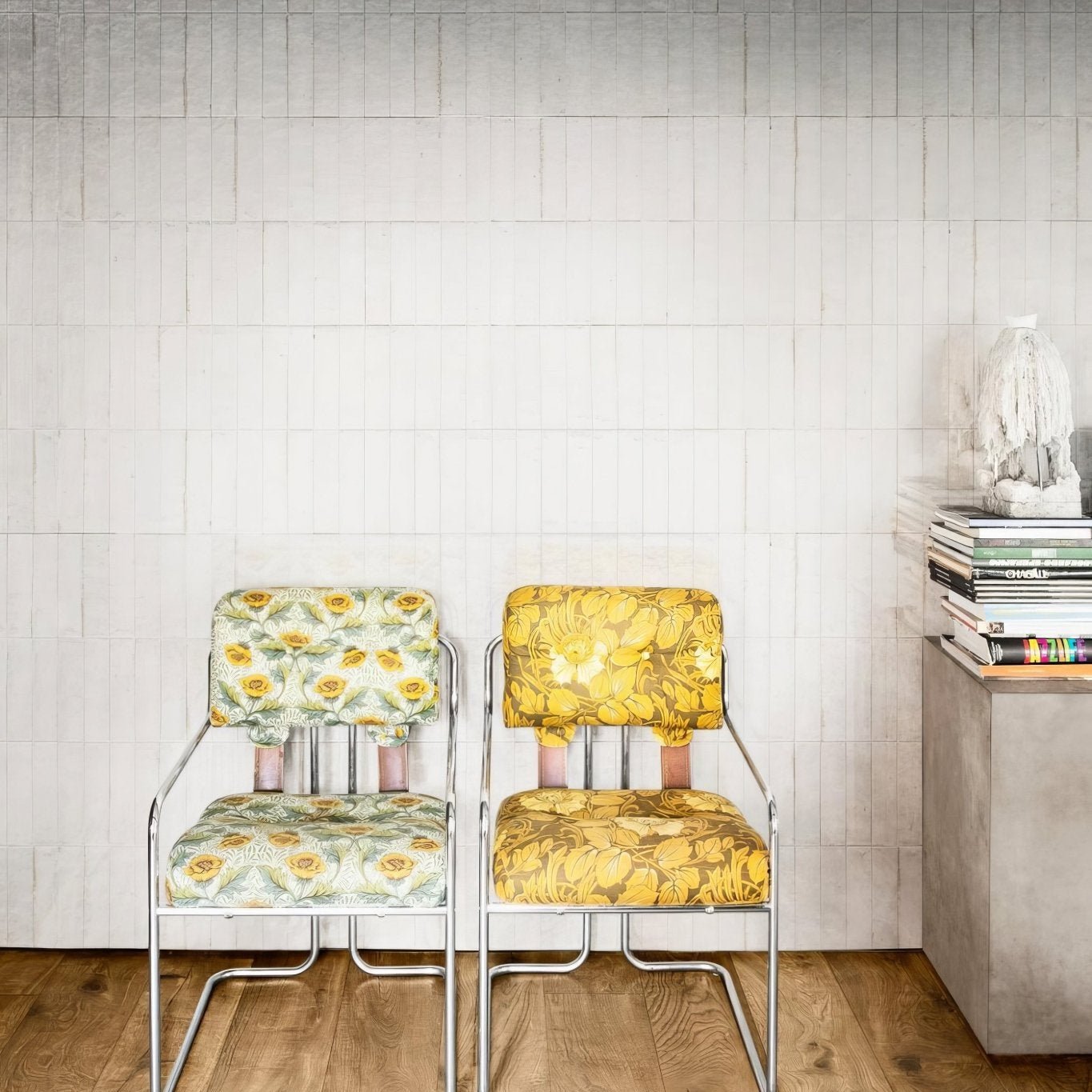 Two luminous lume white vintage-style chairs with chrome frames and bold yellow green cream floral upholstery