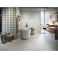 Lyon 1836 Perla Matt light grey marble-effect tiles with a freestanding bathtub