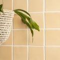 A woven white hanging plant basket with a natural textured pattern featured in maize field tile design