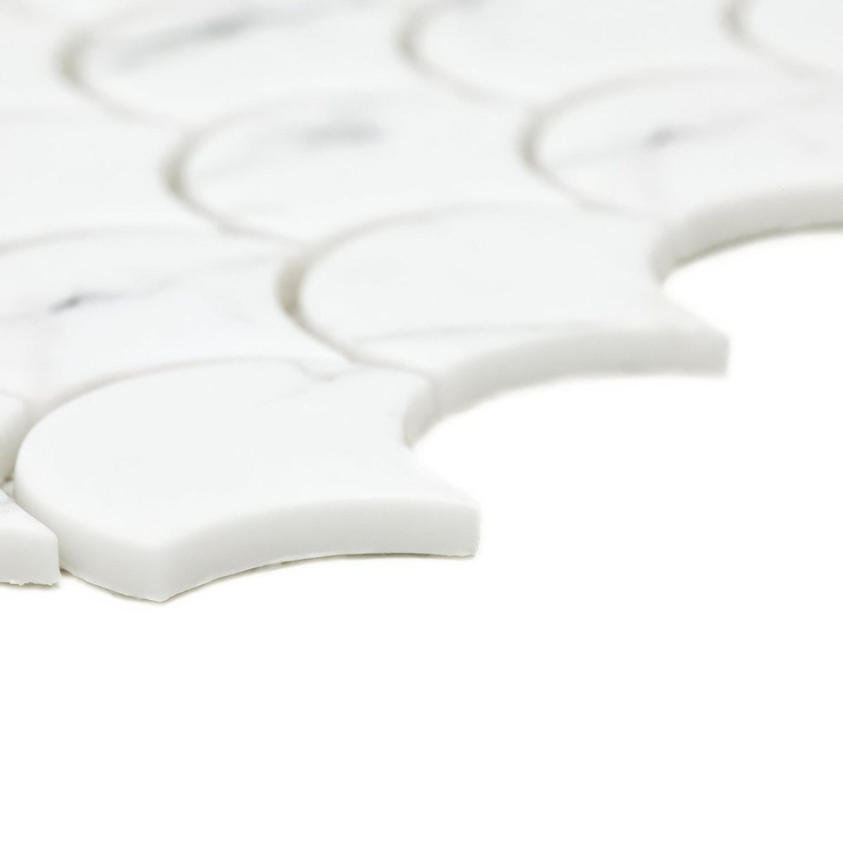 White marble mosaic tiles with a scalloped fish scale design from the malmo scallop white mosaic collection