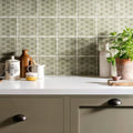 A potted green plant in a textured terracotta pot from Manoir Fleur Pumice collection