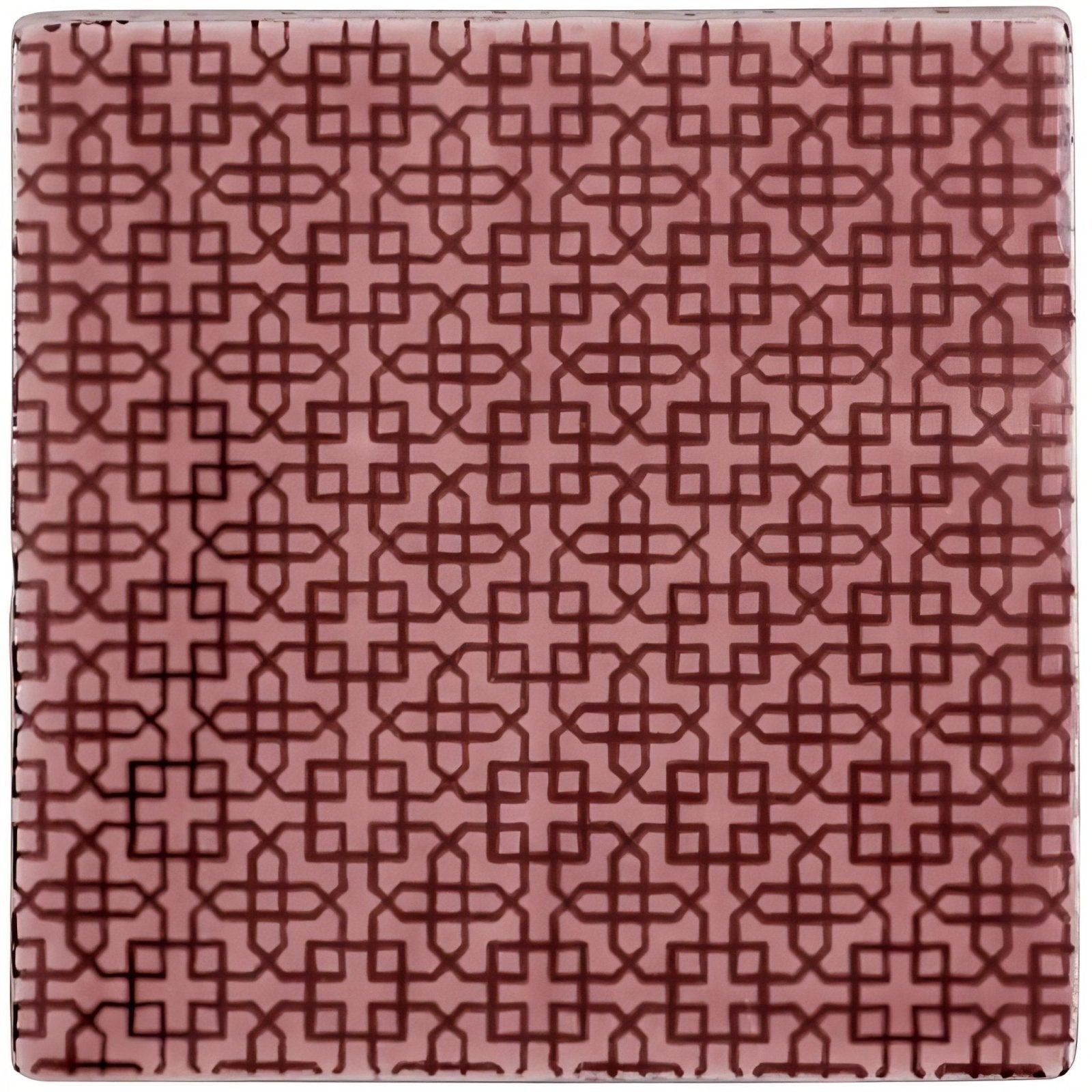 A square ceramic tile manoirt maroc tayberry with matte pink glaze and dark red geometric lattice pattern