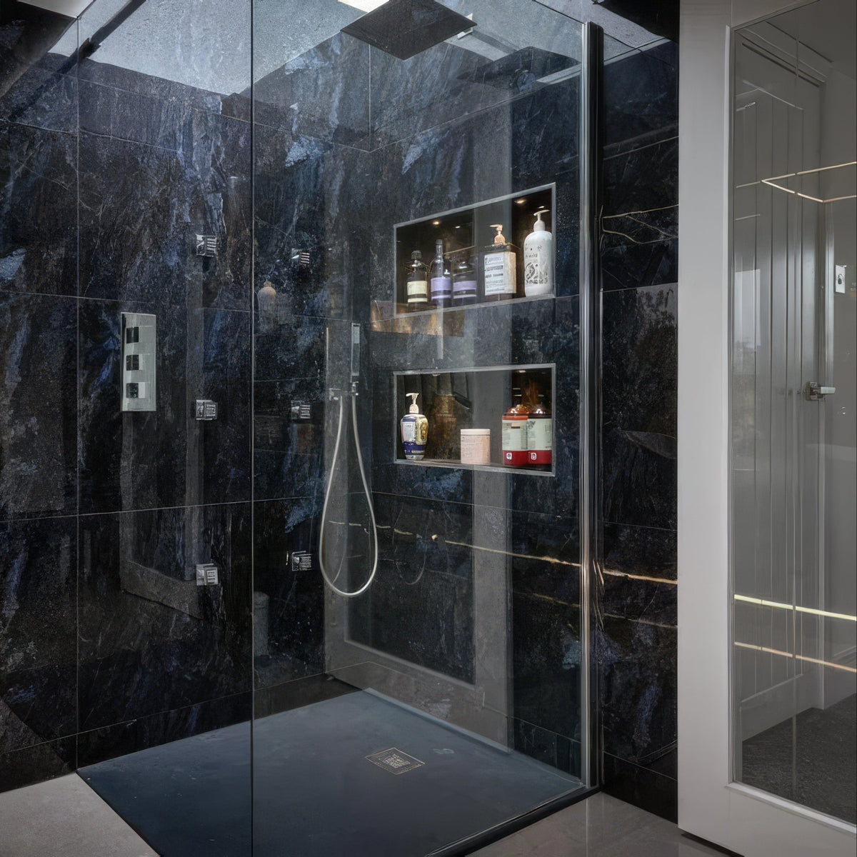 Marble Ocean Rock dark blue marble-effect tiles in a shower enclosure with glass panels and shelving