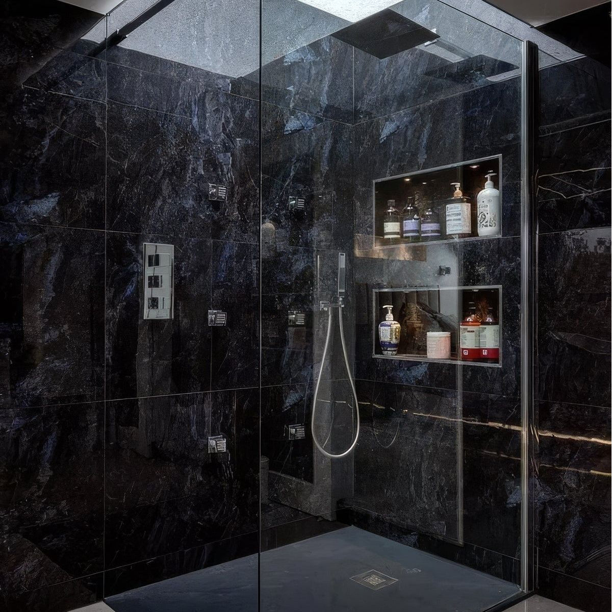 Marble Ocean Rock dark blue marble-effect tiles in a shower enclosure with glass panels and shelves
