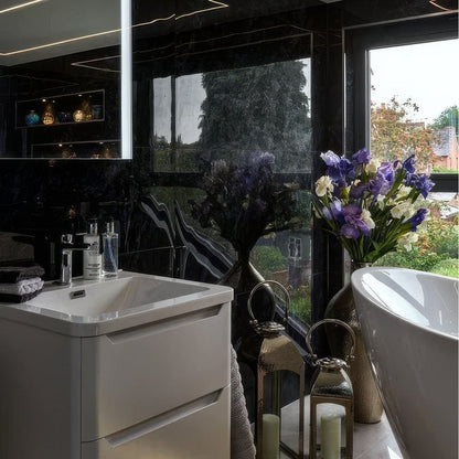 Modern bathroom with white sink, bathtub, and decorative elements.