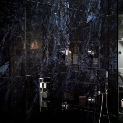 Bathroom with dark marble tiles in Marble Ocean Rock 60 x 120cm and various toiletries on a shelf.