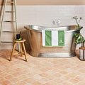 A sleek metallic freestanding bathtub with polished silver finish and rounded edges called Marlborough terracotta arabesque