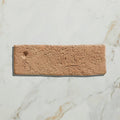A rectangular marlborough terracotta bejmat brick with a textured earthy terracotta surface and natural imperfections