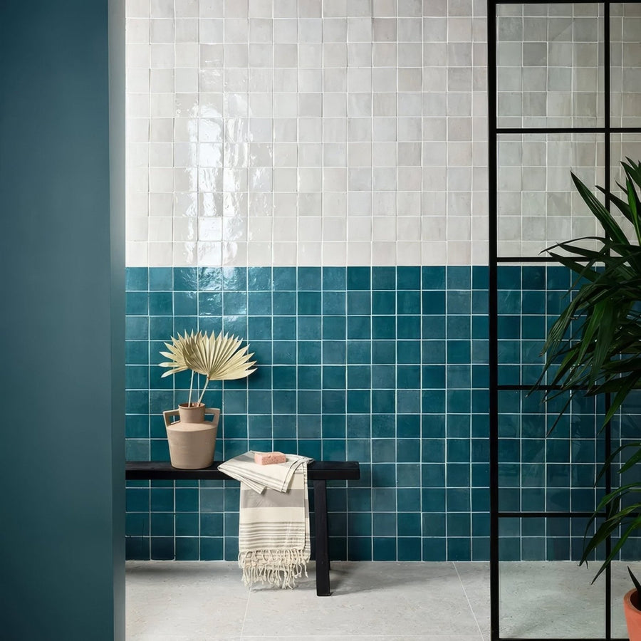 The wall features maroc ceramic aquamarine glossy square tiles in white and teal blue two-tone design