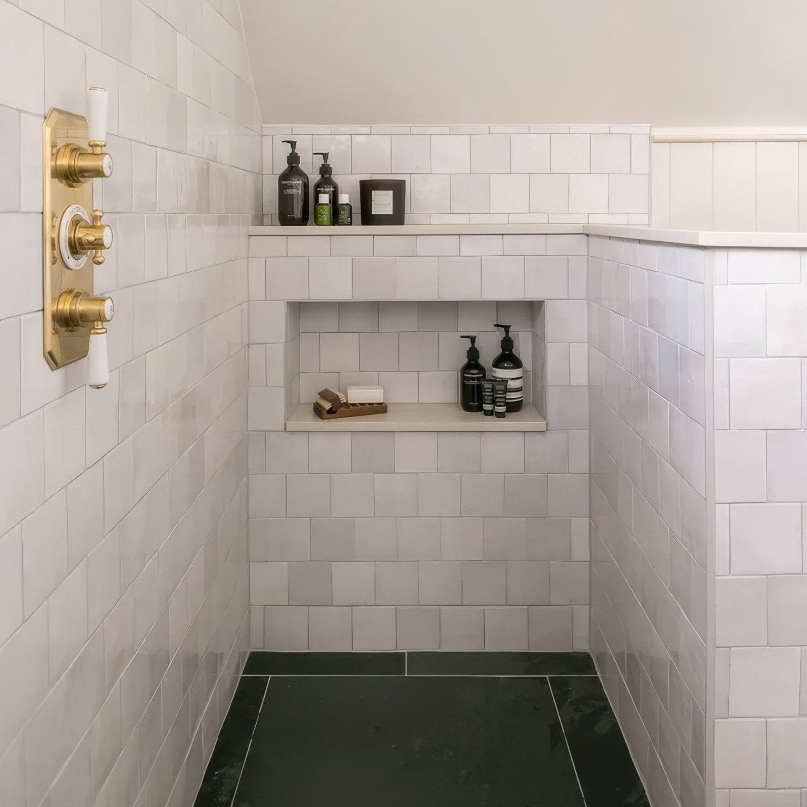 Gold-tone wall-mounted shower faucet with white ceramic handles from Maroc ceramic Bianco collection