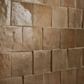 Beige ceramic caramel stone effect tiles with matte textured finish arranged in a staggered pattern