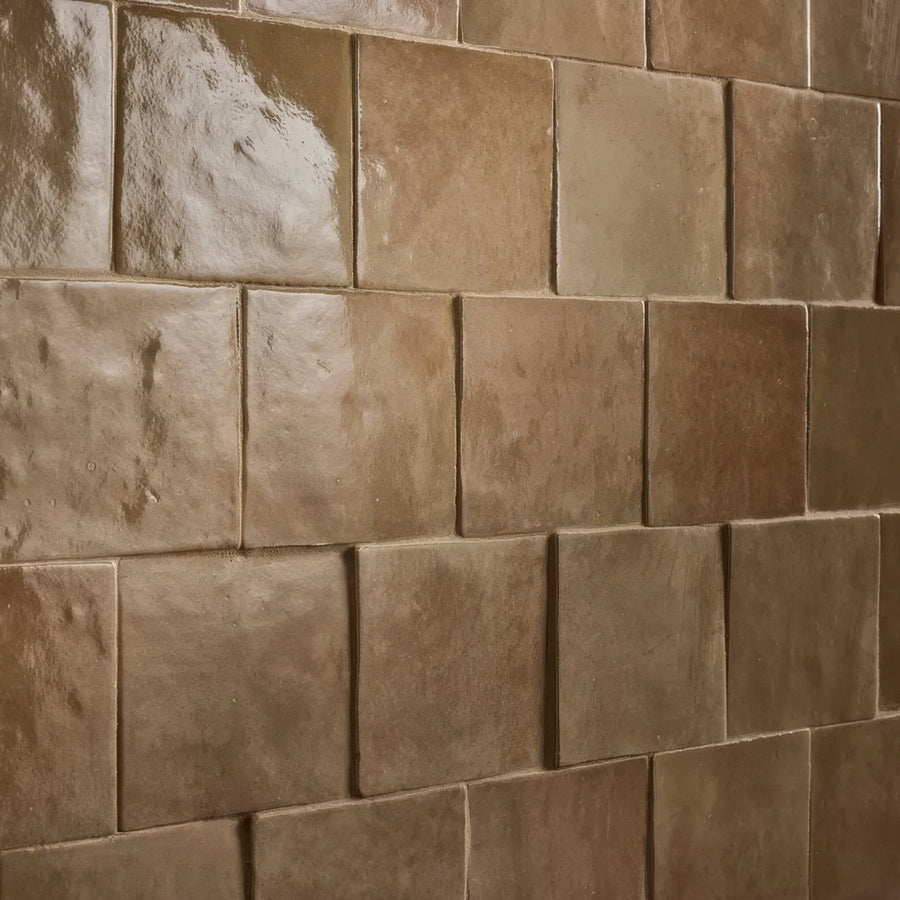 Beige ceramic caramel stone effect tiles with matte textured finish arranged in a staggered pattern