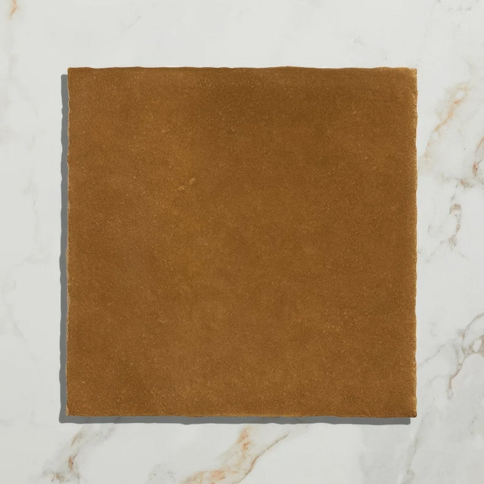A square tan-colored suede ceramic tile with a soft textured surface from maroc ceramic khaki collection