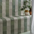 Green and white ceramic square tiles with a subtle glossy finish forming a patterned wall for interior decor