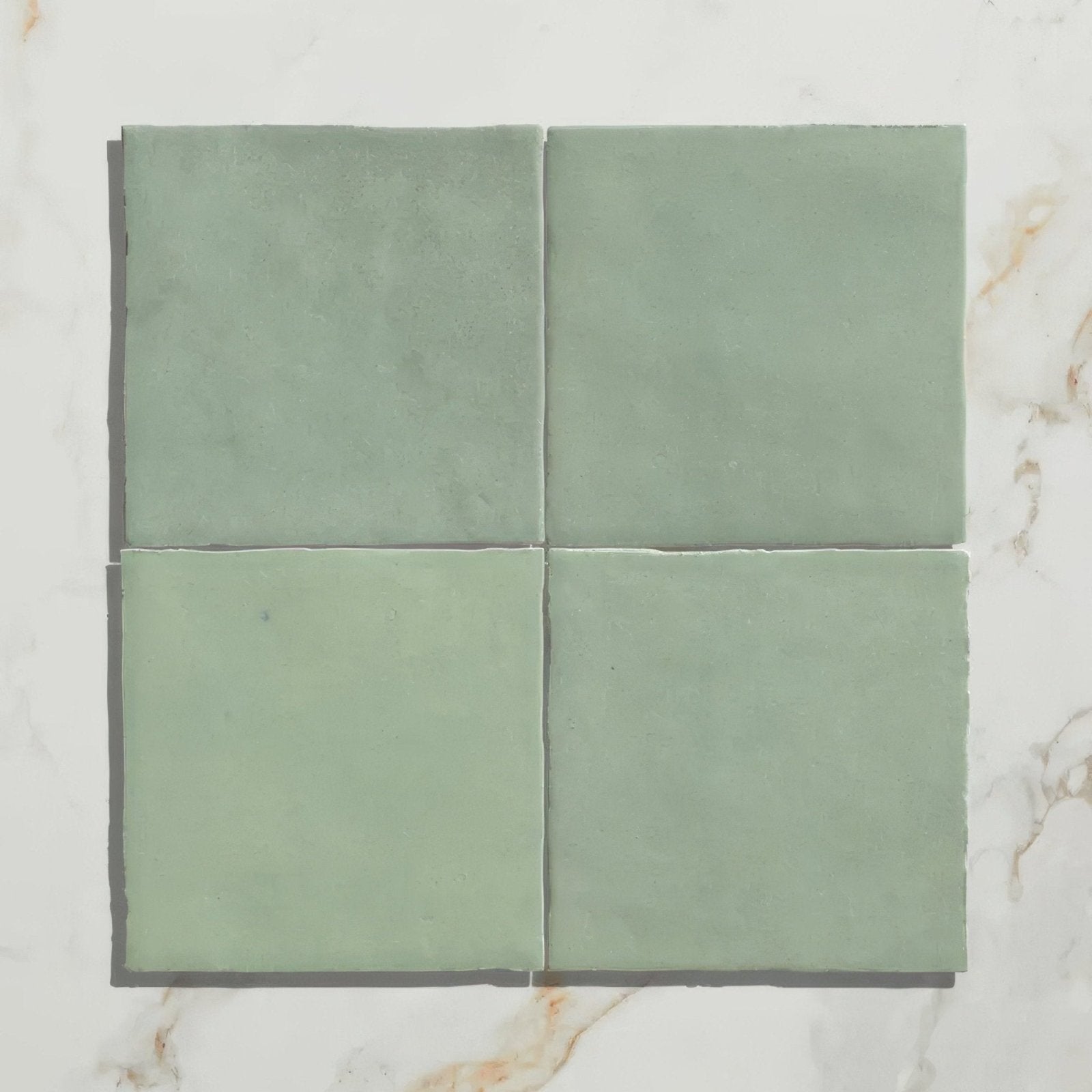 Four square matte-finished sage green ceramic tiles arranged in a grid from maroc ceramic mint collection