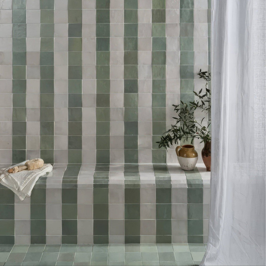 Green and white striped ceramic tiles from maroc ceramic mint forming a vertical pattern on a bathroom wall
