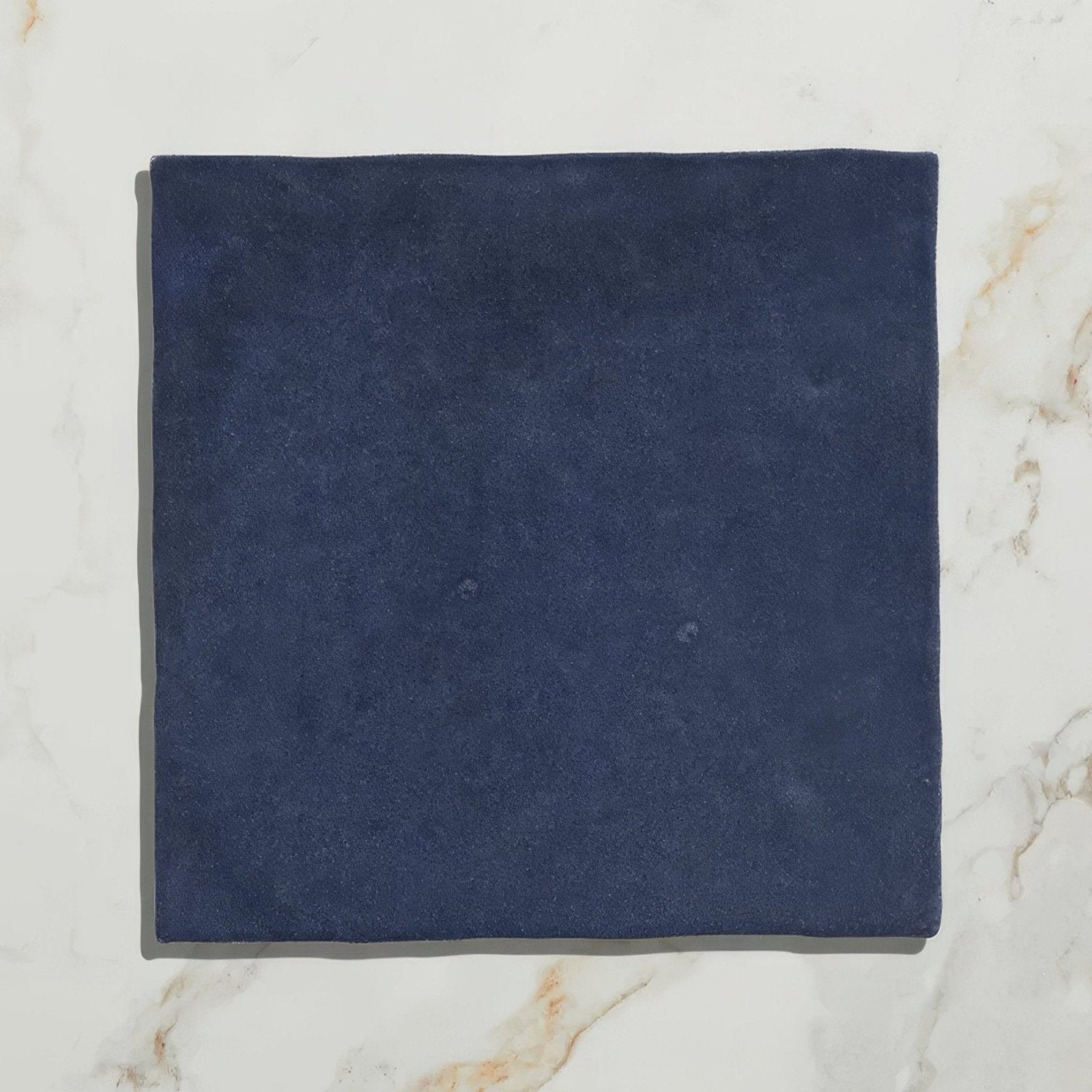 A square navy blue suede coaster from maroc ceramic oltremare perfect for protecting surfaces