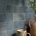 Maroc ceramic powder blue featuring a speckled off white ceramic pitcher with curved handle beside terracotta jug