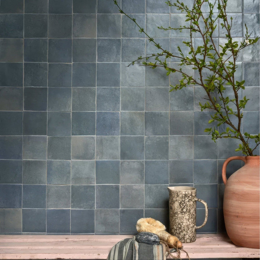Gray-blue square ceramic tiles with a matte textured finish forming a wall in maroc ceramic powder blue style