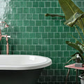 Maroc ceramic teal deep green rectangular matte textured wall tiles behind black clawfoot bathtub