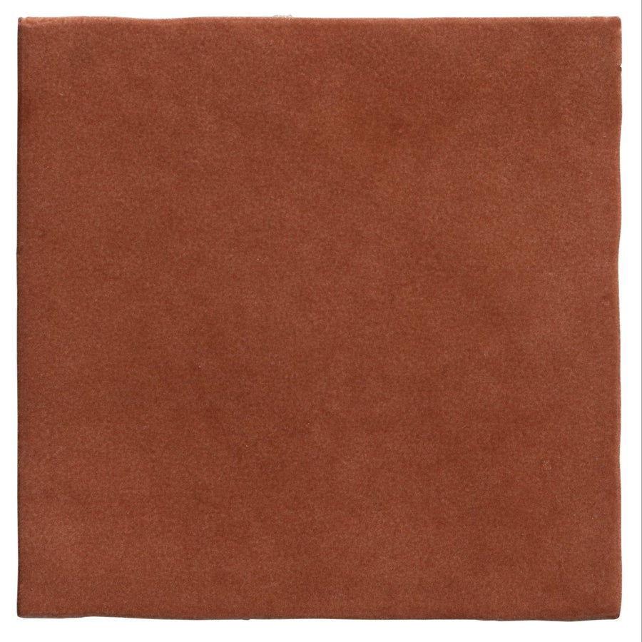 A square terracotta-colored ceramic tile with a matte textured surface from maroc ceramic tomato collection