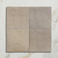 Four square beige ceramic wool tiles with a matte slightly textured surface arranged in a grid for wall or floor use