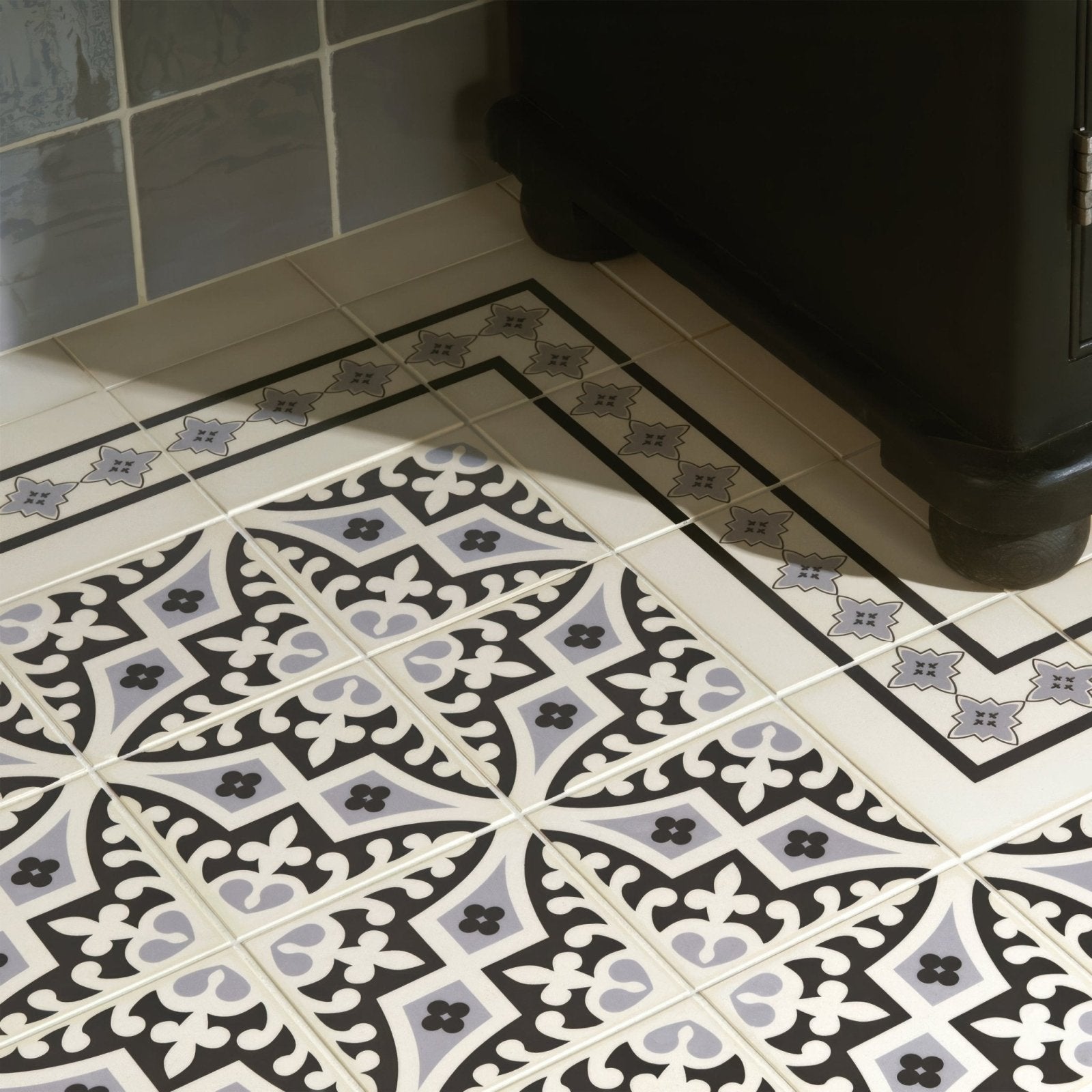 Black white and gray patterned ceramic floor tiles with ornate floral designs in marrakech border light grey and black on white