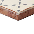 Cream-colored ceramic Marrakech El Hara patterned terracotta tile with rustic textured edge and subtle gray leaf design