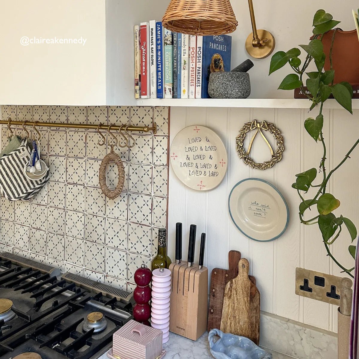 Wooden knife block with black handled knives neatly arranged in slots complements moroccan el hara patterned terracotta tile