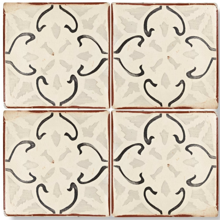 Cream-colored Marrakech Mabrouka patterned terracotta tile with black hand-painted floral patterns and rustic brown border