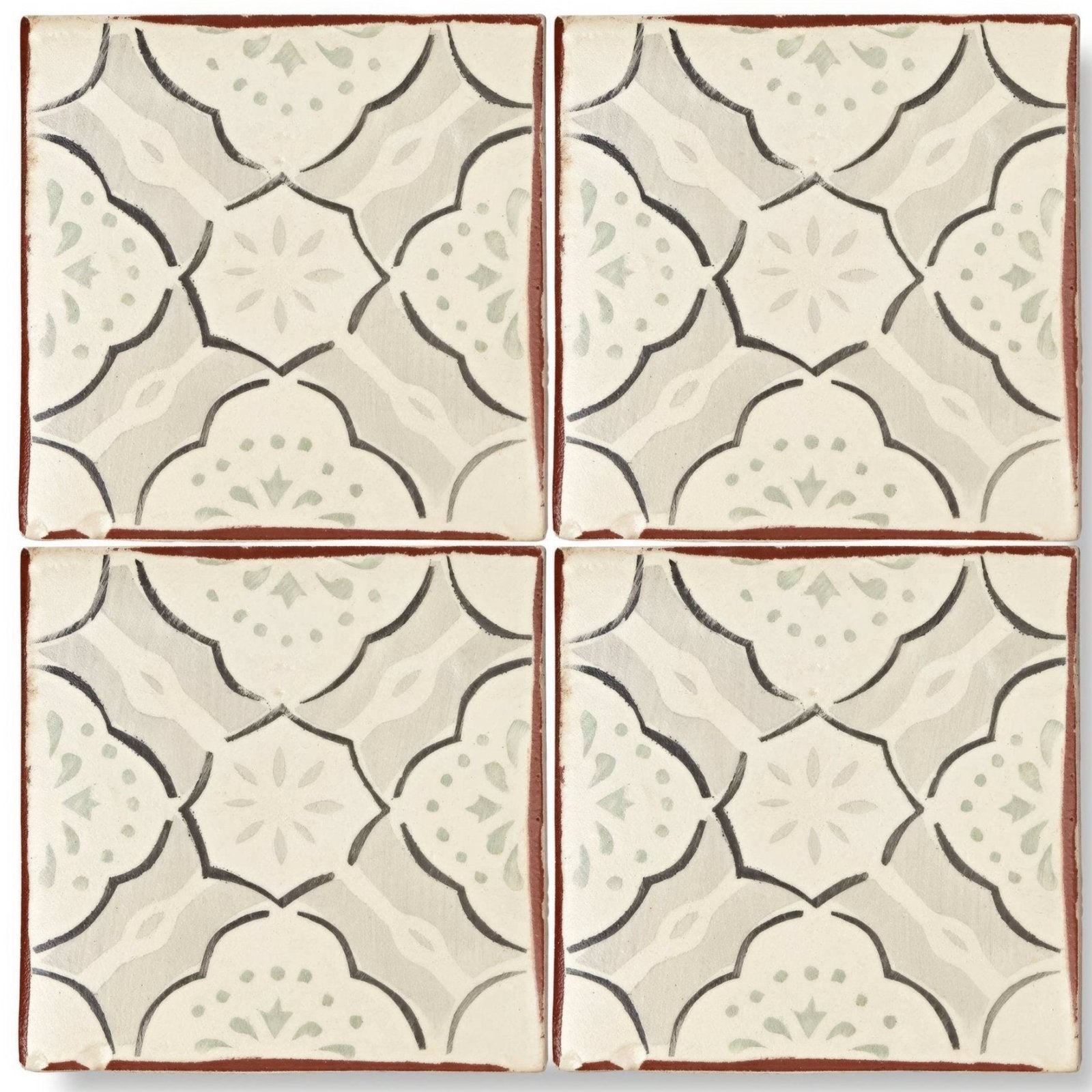 Four square cream terracotta tiles with dark brown floral outlines and green accents in the marrakech menara pattern