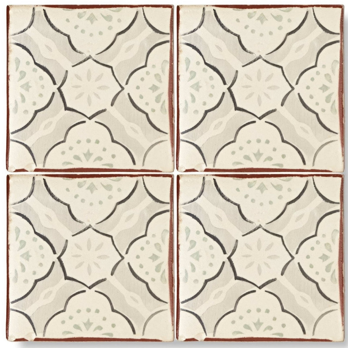 Four square cream terracotta tiles with dark brown floral outlines and green accents in the marrakech menara pattern