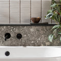 Matchstick Ice white glass mosaic with a black wall-mounted bath tap
