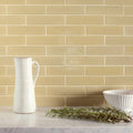 White ceramic pitcher with vertical ribbed texture and curved handle featured in meadow brick tile setting