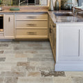 Beige kitchen cabinets with sleek black handles and stone countertop featuring vieux bourgogne limestone cobbles weathered finish