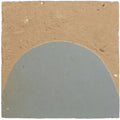 A matte gray semi-circular handmade moroccan zellige tile from medina cornflower blue set on a textured tan background