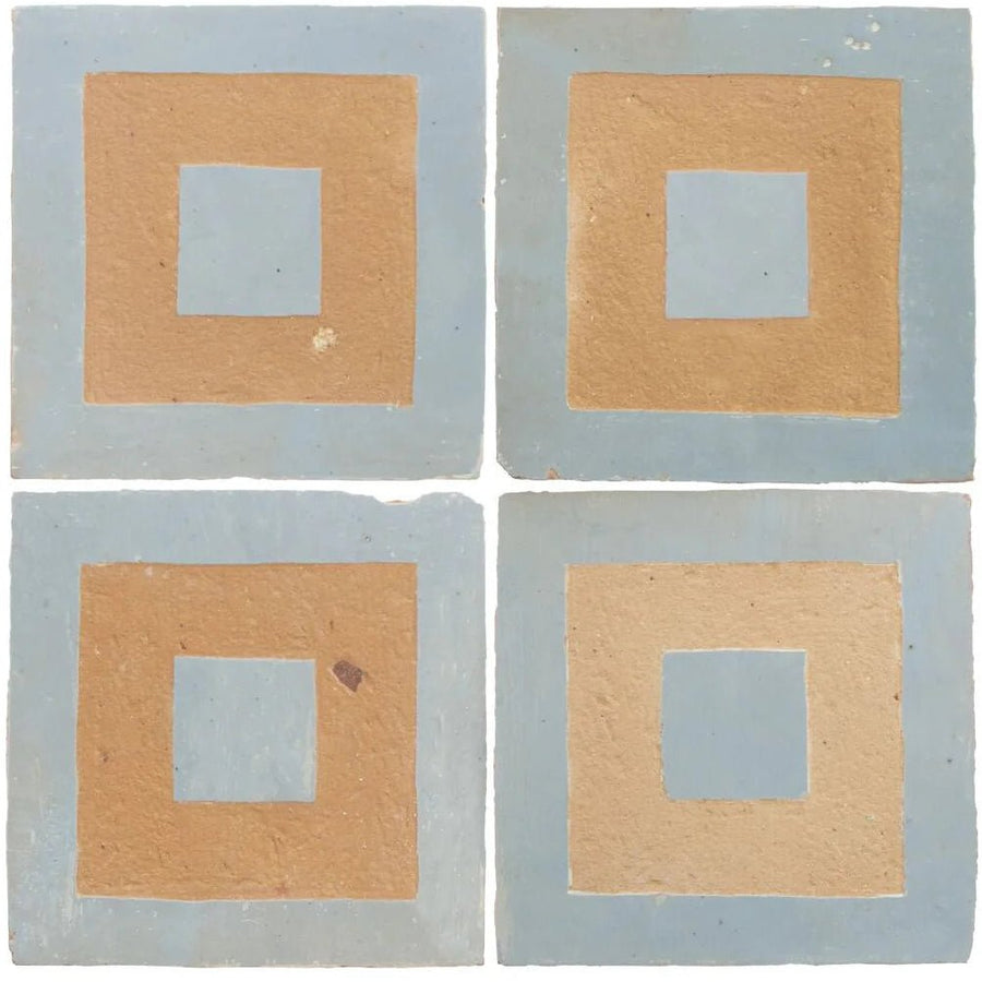Set of four handmade Moroccan zellige ceramic tiles featuring layered geometric design in cornflower blue and tan