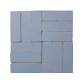 Set of light blue rectangular ceramic tiles arranged in a herringbone pattern medina cornflower blue zellige rectangle