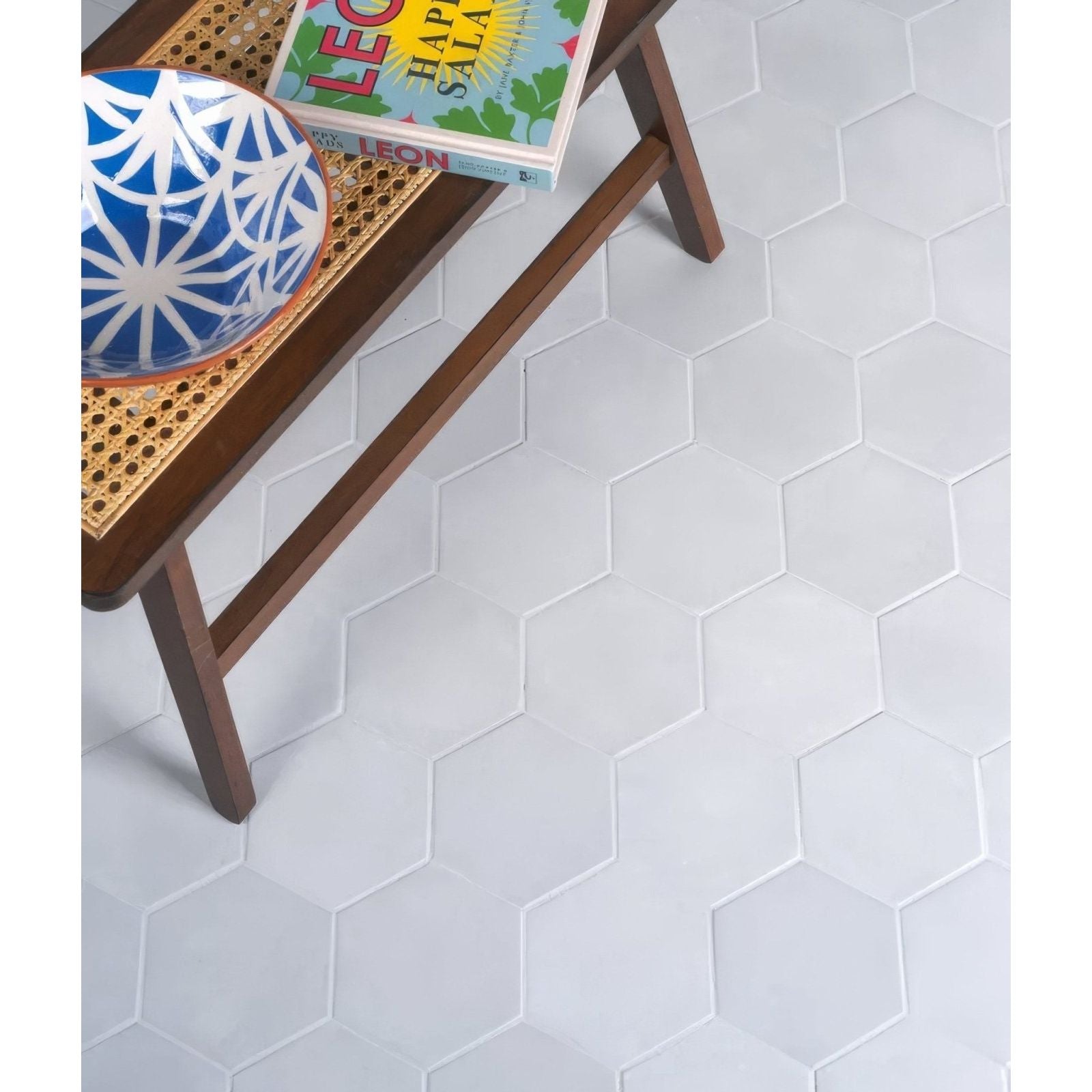 White hexagonal porcelain floor tiles with subtle gray grout lines in medina hexagon porcelain latte design